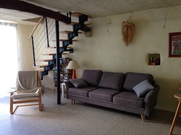 Sofá cama y sillón de la sala de estar. Escalera que da acceso a la habitación en el piso superior