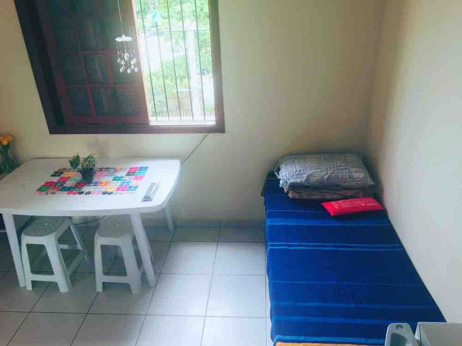 Sala e um sofá que serve de cama de solteiro