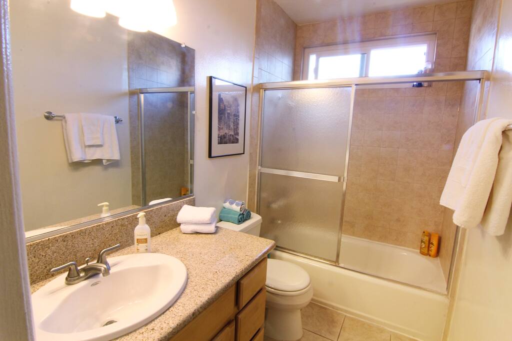Clean and fresh bathroom with granite counters and tile floors
