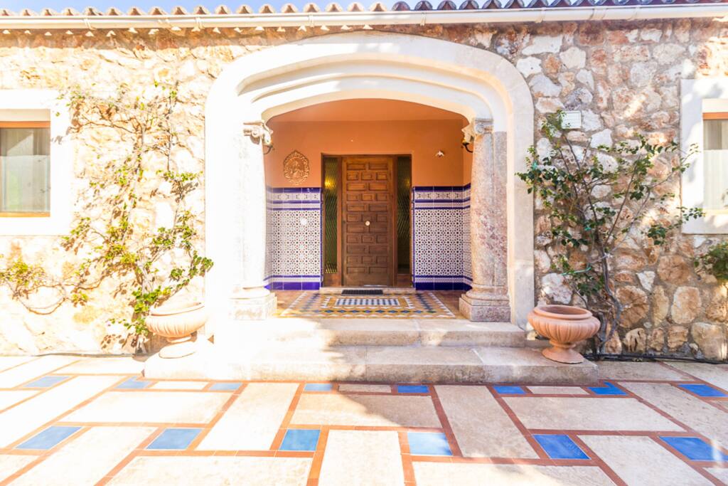 Vista de la entrada de la casa, diseñada con el estilo y carácter típico andaluz. Los escalones conducen a la entrada con una exuberante buganvilla.