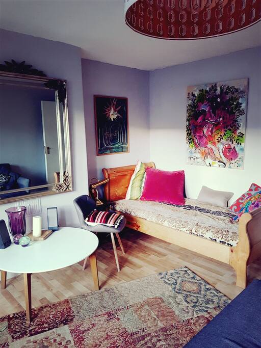 The antique day bed in the living room with original artworks