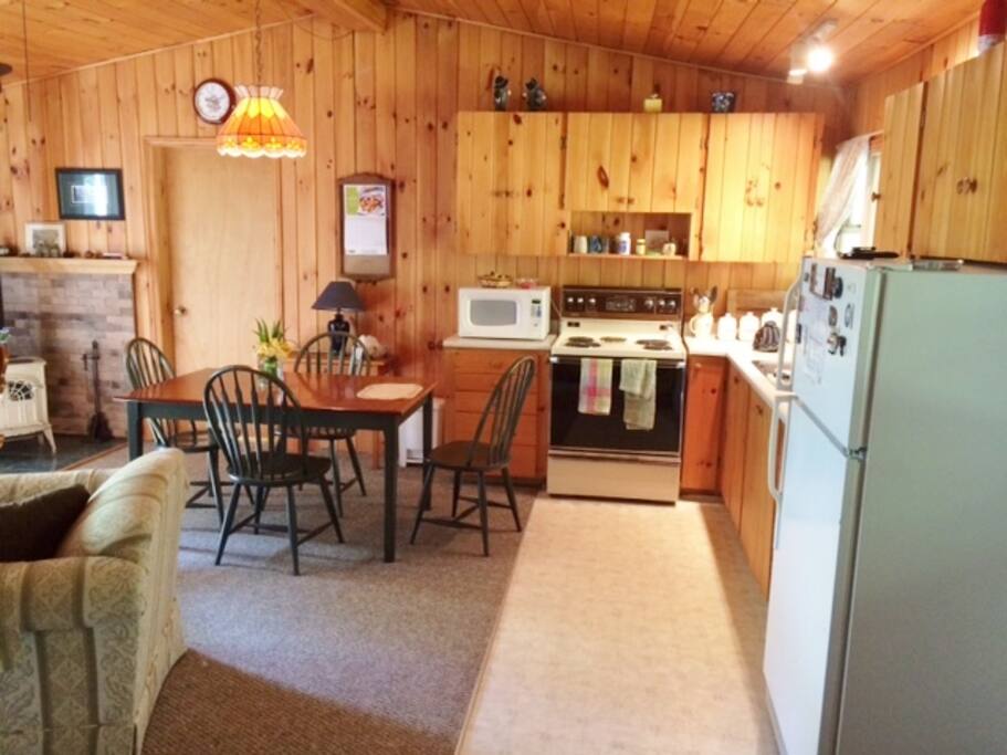 Interior showing kitchen area, pine cupboards and clean, fully functional appliances.