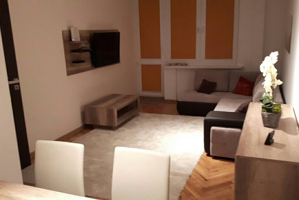 Wohnzimmer mit Balkon, TV, Esstisch, Schlafcouch