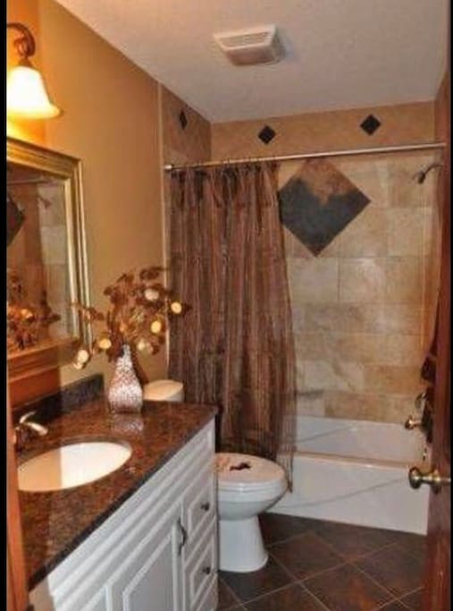 Main bathroom upstairs, granite counter top, single sink, shower/bath. (Please note, decor may be different during your stay)