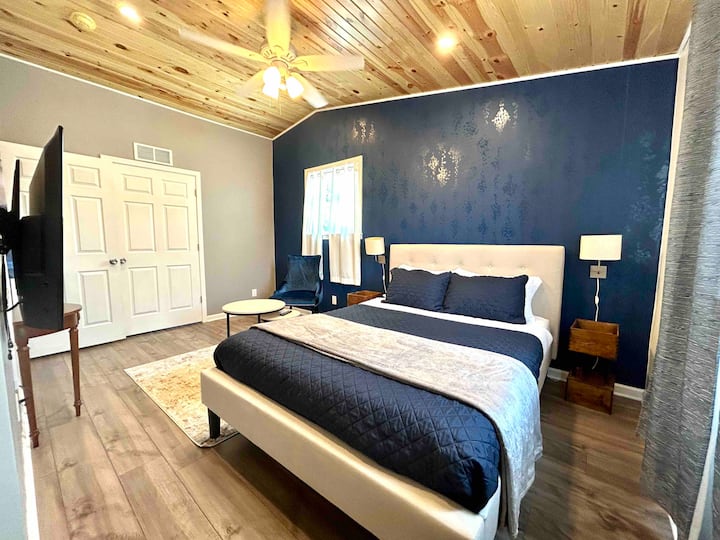 Chumba cha Bluu kilicho na kitanda aina ya queen na televisheni ya skrini tambarare. 