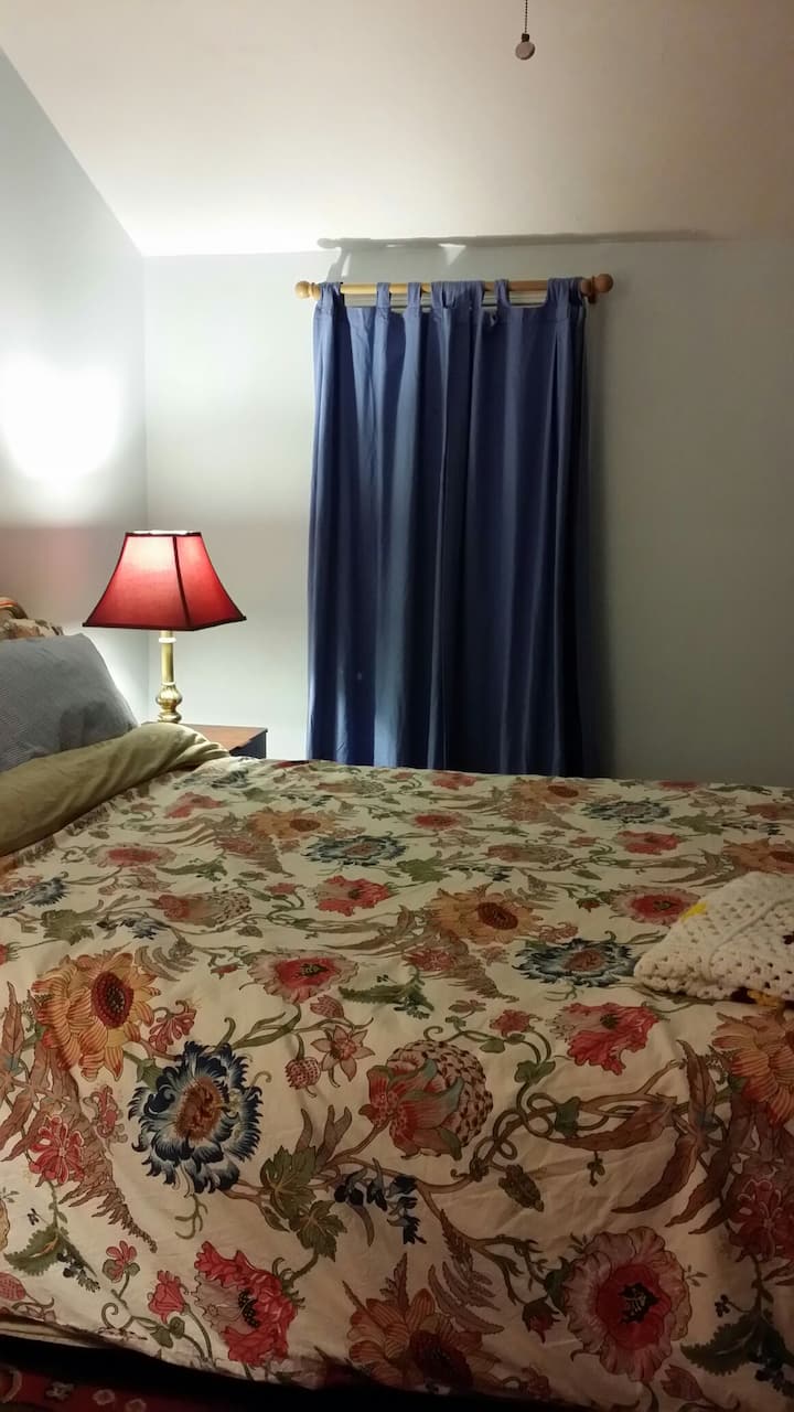 Menšia manželská posteľ s útulným starožitným nábytkom