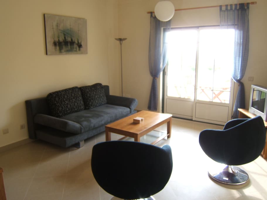 Siting area with door to main balcony which overlooks the pool and has a sea view