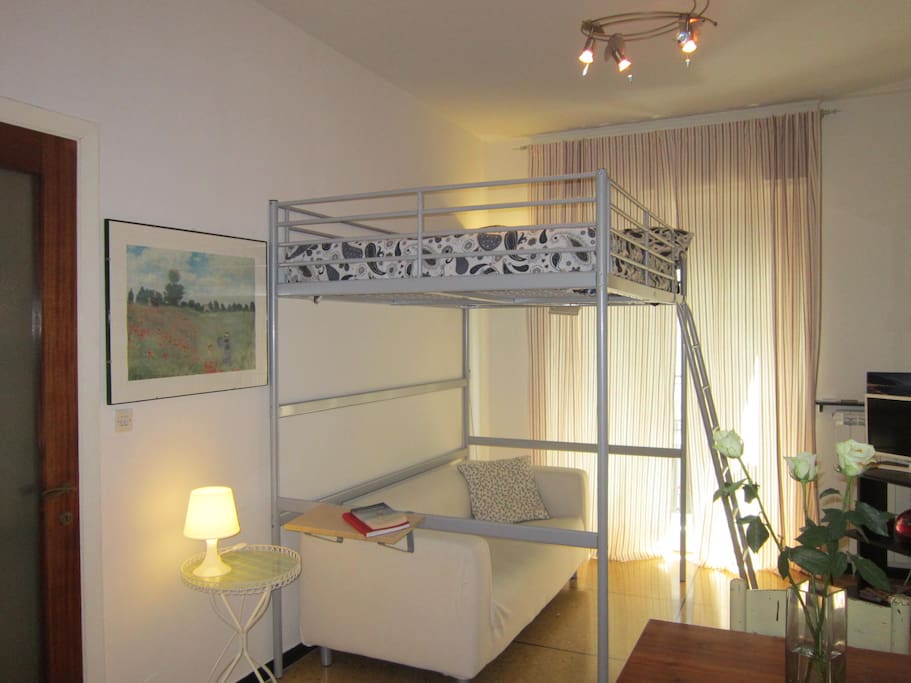 Soggiorno con letto matrimoniale a soppalco. Living room with a king size loft bed