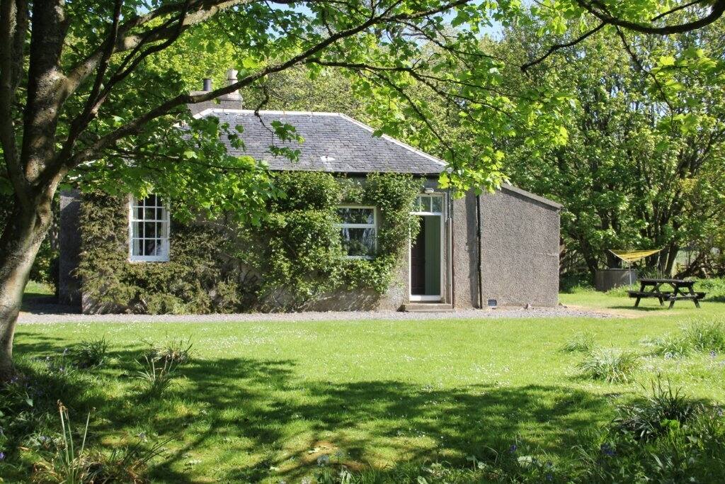 The front of the cottage as vast lawn with beach and ocean view.