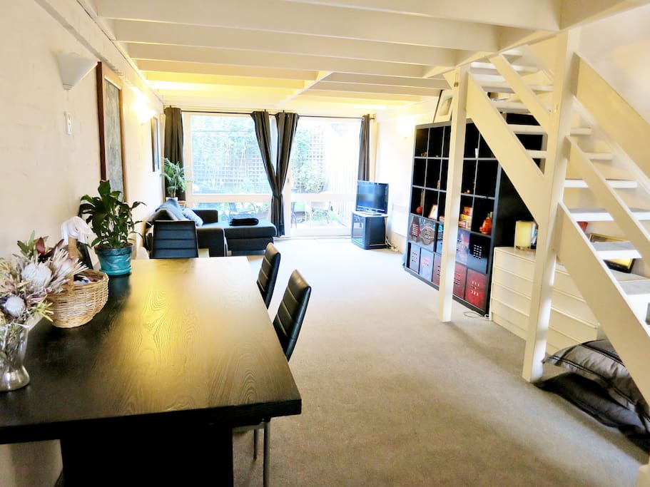 Living area and courtyard looking from Kitchen. Black dining table and bookcase will not be included.