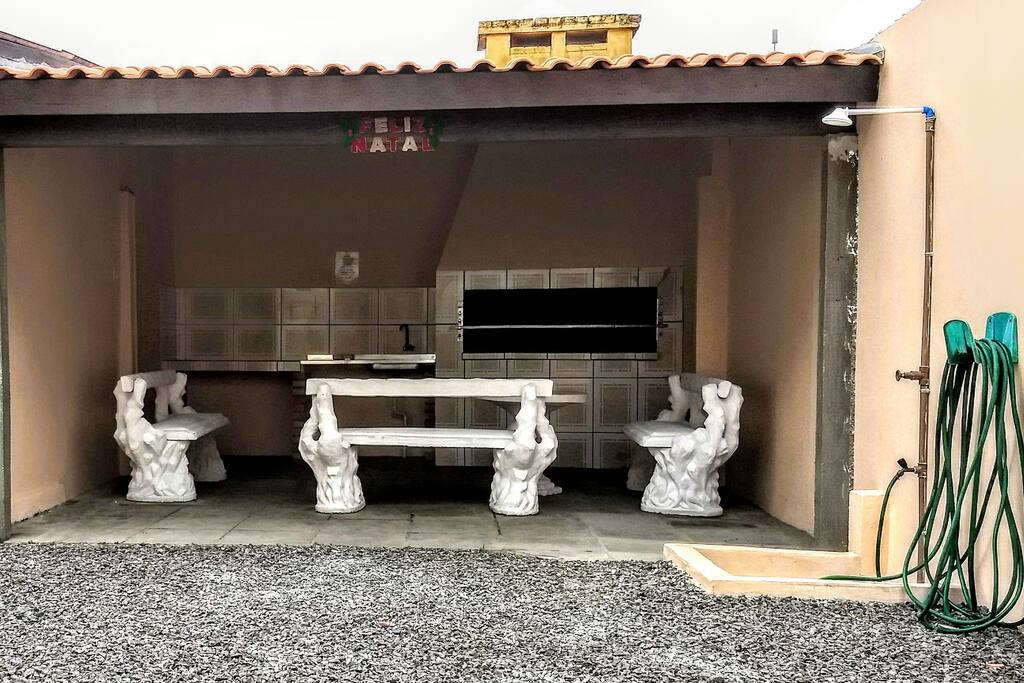 Área comum de lazer com churrasqueira e chuveiro.