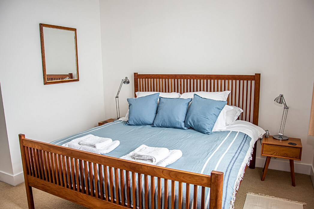 חדר שינה ראשי מס '1 עם מיטת קינג סייז (המשקיפה על האגם) וחדר רחצה צמוד.