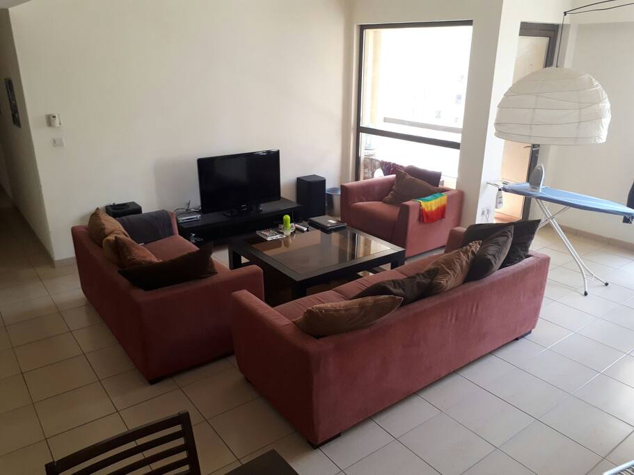 This is our super cosy living room with many TV channels and a dining area. There is access to the balcony from here and also space to dry and iron your clothes.