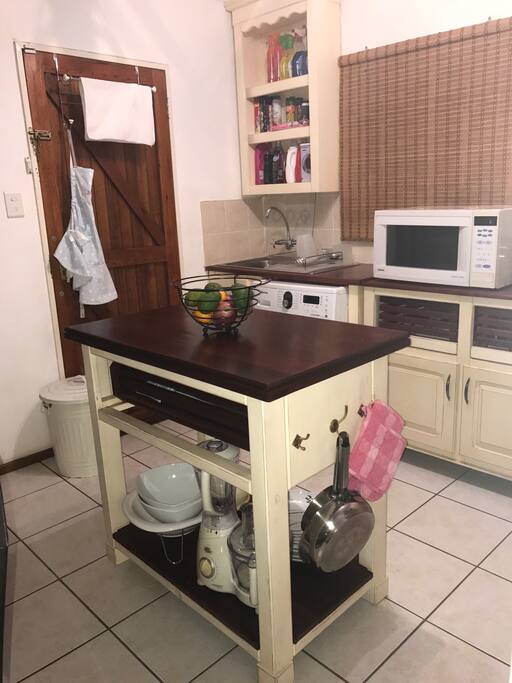 Kitchen with stove, microwave oven, washing machine and other essentials.