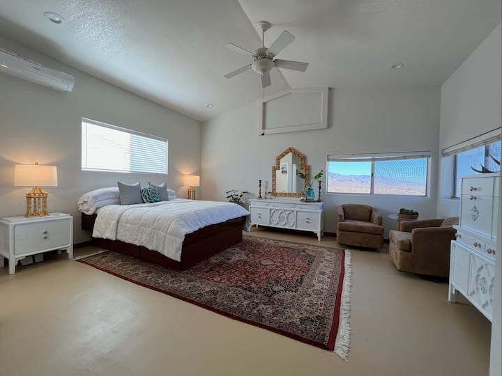 宽敞的卧室，配备加大双人床和休息区