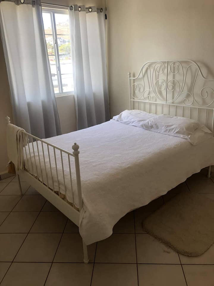 Spavaća soba s bračnim krevetom i prozorom.