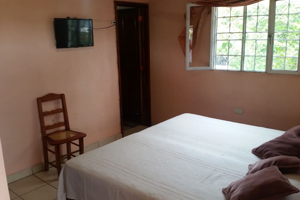 Cuarto con cama matrimonial, cuenta con tv con cable