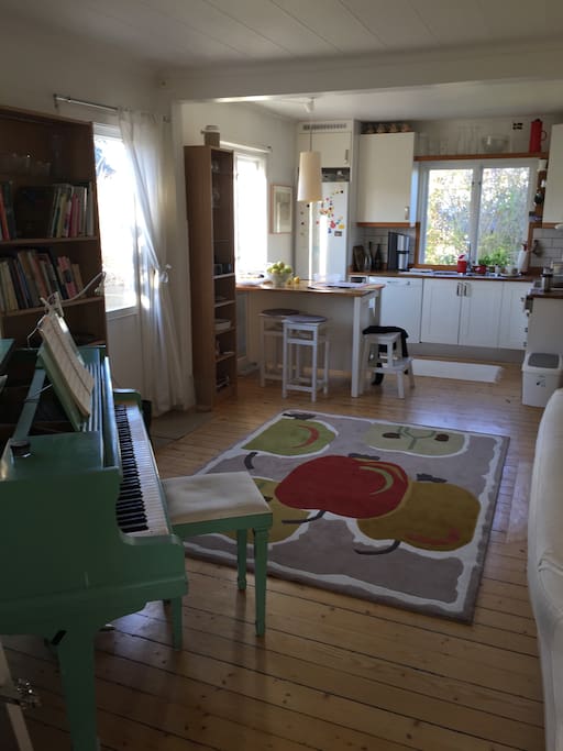 The livingroom and the kitchen also includes a grand piano.