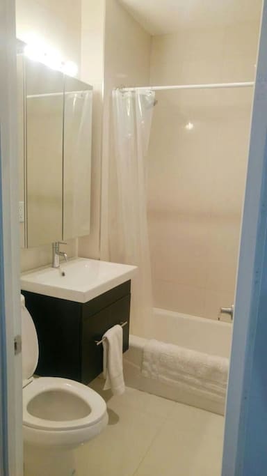 Private bathroom located inside bedroom with bathtub and shower.