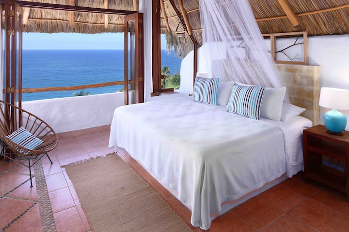 Vistas al mar desde el dormitorio palapa. Cama tamaño king y ventilador de techo.