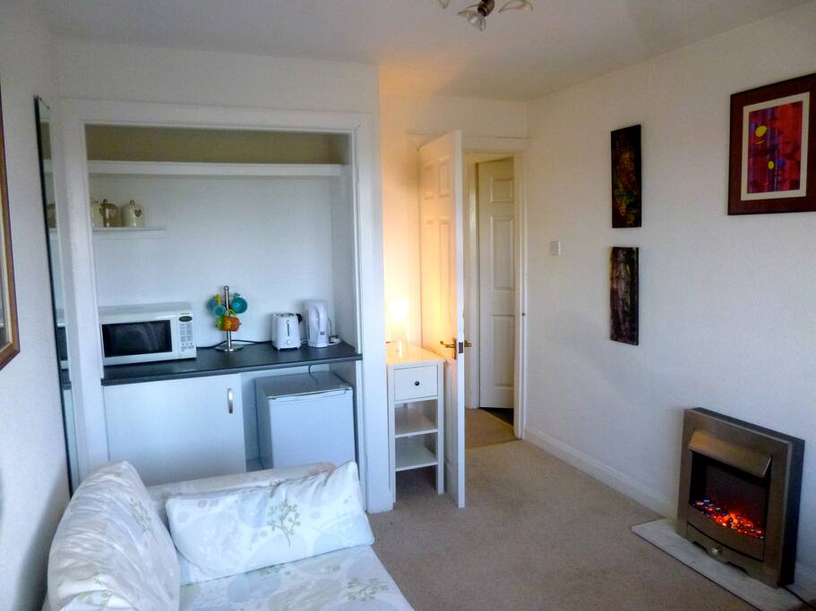 Sitting room with TV, mini-fridge, microwave, toaster and desk.