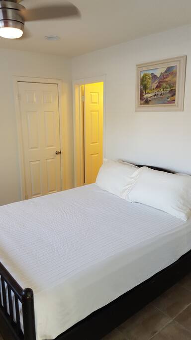 Queen sized bed with wall mounted TV