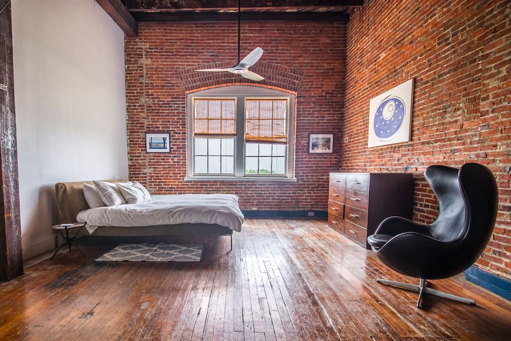 Spacious master suite with B&B Italia king sized bed with natural latex mattress and black leather Arne Jacobsen Egg chair.
