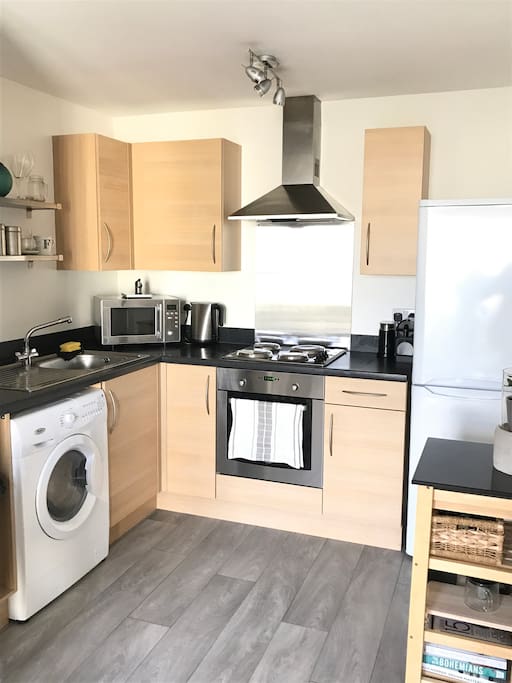 Open plan kitchen with washer/dryer, electric cooker/grill/oven, microwave, fridge/freezer, Nespresso coffee machine, kettle and toaster.