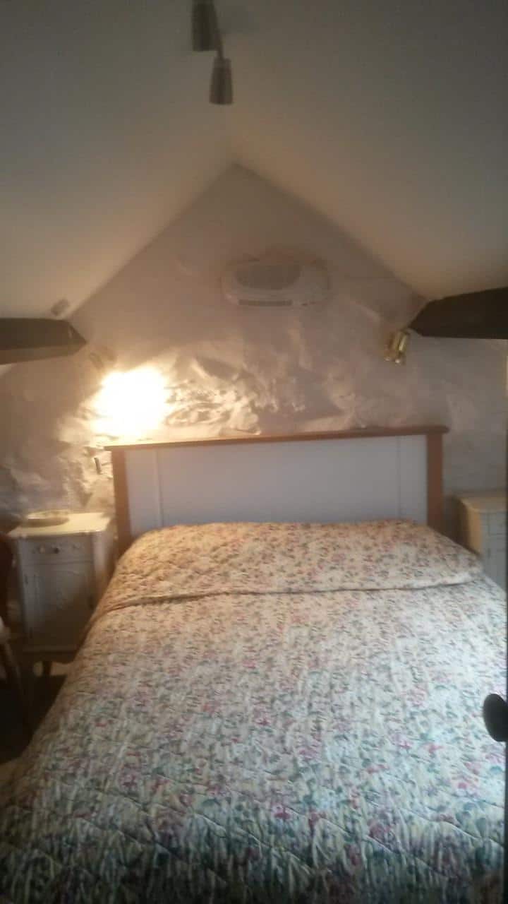 Chambre à coucher avec lit double, armoire et commode.  Stockage également disponible sous les combles.  Fenêtre Velux avec vue sur la montagne des éléphants (Mynydd Mawr)