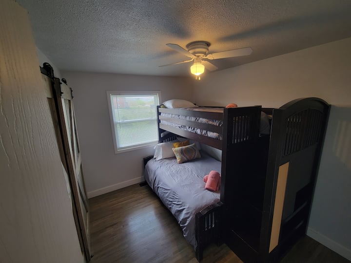 双层床房，下铺为全尺寸床，上铺为单人床。 卫生间就在走廊对面。 