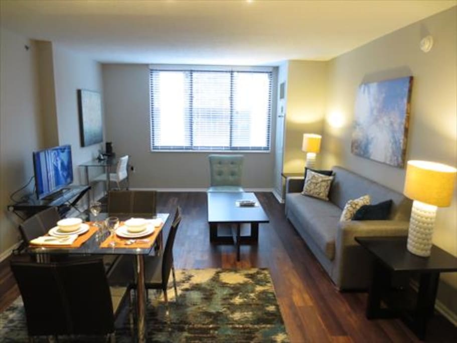 Spacious living room with seating area, dining area, entertainment center and convenient work desk