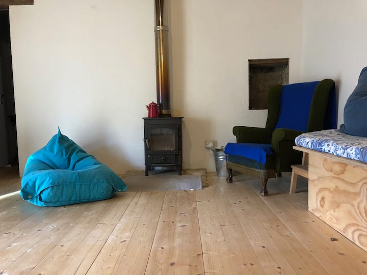 Living room, stove, armchair, teapot.
