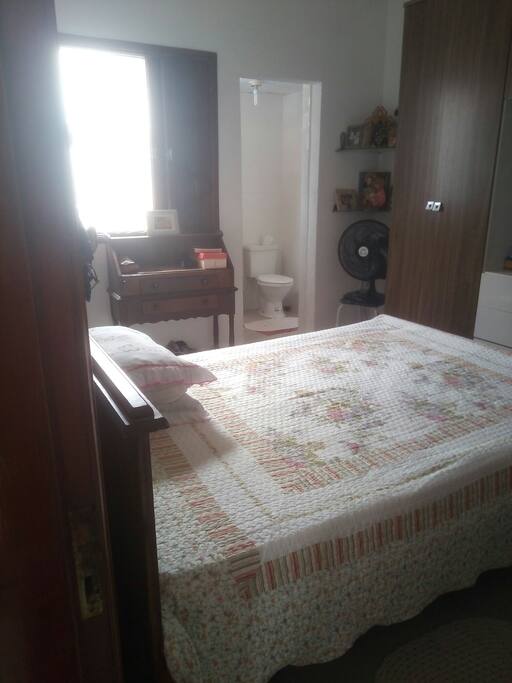 Suite casal com guarda roupas,penteadeira,ventilador de teto e de chão .O banheiro só tem vaso sanitário.