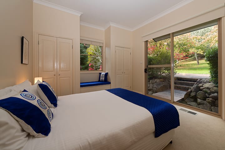 El dormitorio 2 de la casa Dantosa tiene una cama queen y sus propias puertas corredizas de vidrio al jardín. 