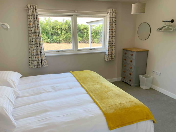 Chumba cha kulala 1/Chumba kikuu cha kulala kilicho na kitanda cha kifalme ambacho pia kinaweza kugawanywa kuwa mapacha. Mwonekano wa bustani binafsi