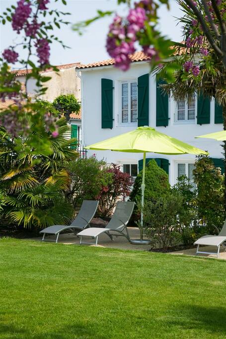 Terrasse privée avec transats, salon de jardin et parasol