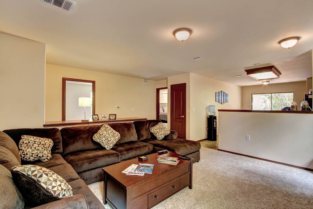 Large over sized couch with pillows, fresh blankets.