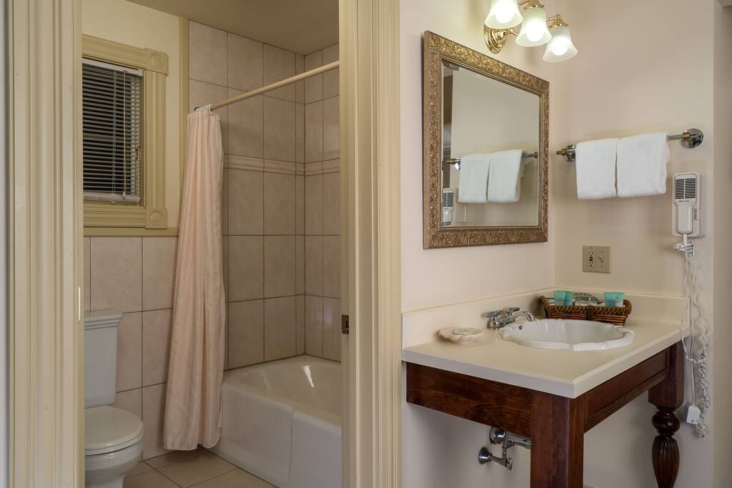 The pristine bathroom comes equipped with amenities and plush towels.