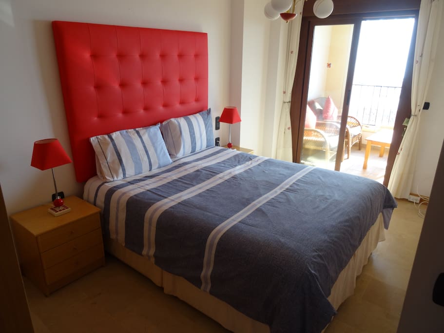 masterbedroom met inbouwkast, badkamer, terras en uitzicht op zee