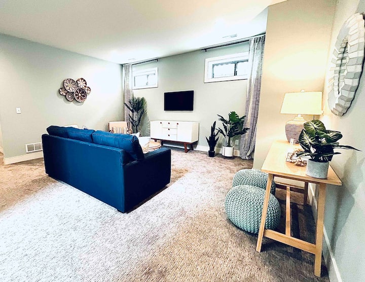 Жилищно пространство на по - ниско ниво със смарт телевизор, множество възможности за сядане и разтегателен диван с двоен размер