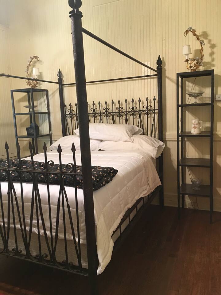 The second bedroom has a queen poster bed made from fancy vintage iron fencing