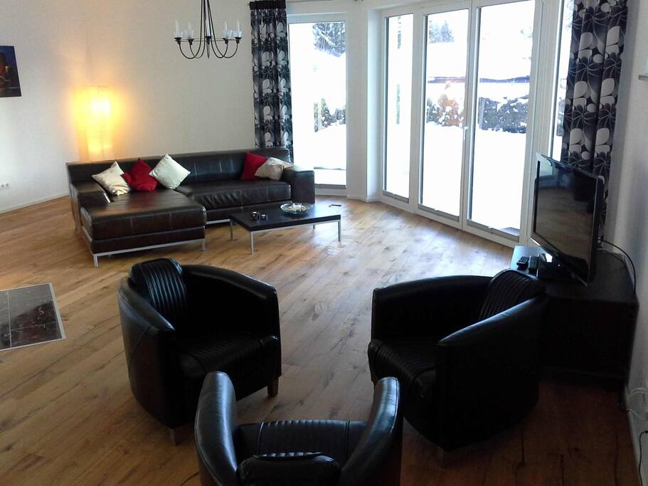 Großzügiges Wohnzimmer mit Zugang zur Terrasse und Kamin.