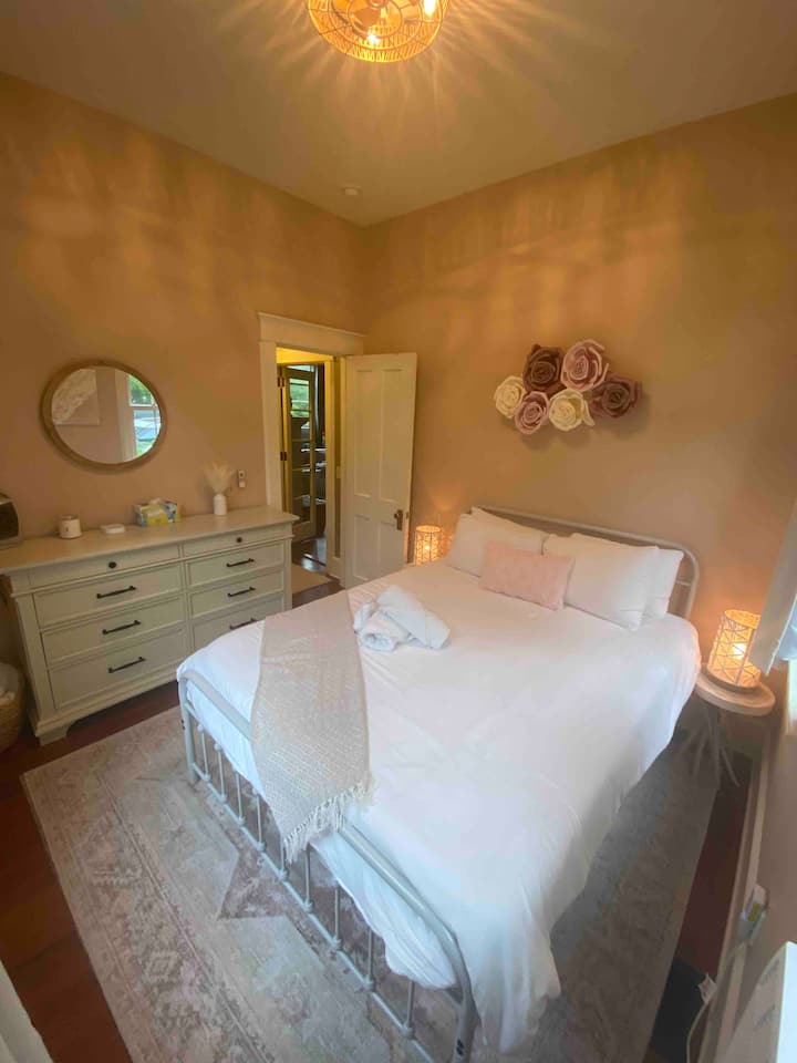 Dormitorio queen con ventilador de luz de techo. El aire acondicionado de la ventana se instaló a mediados de junio y se retira a finales de septiembre. 