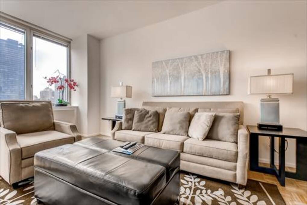 Spacious Living Room with pullout sofa bed as well as large windows to experience the city views