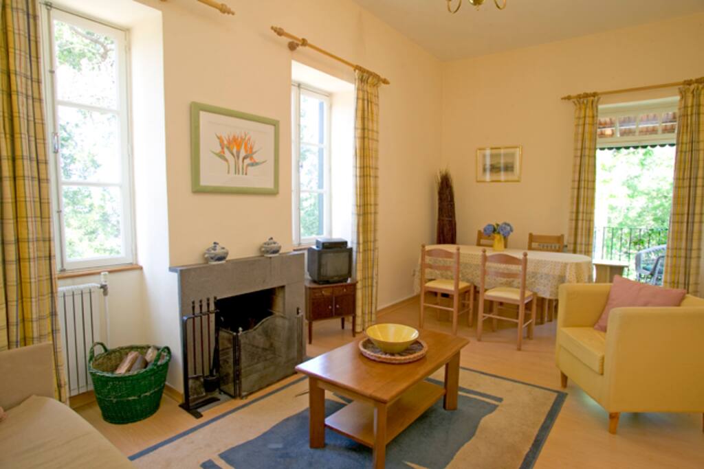 Light and airy living room with doors to the verandah and an open fire.