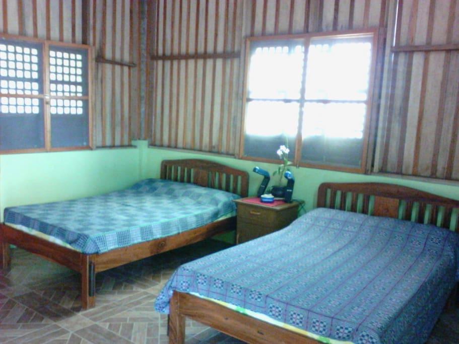 The two double beds inside the room, also featuring antique capiz windows.