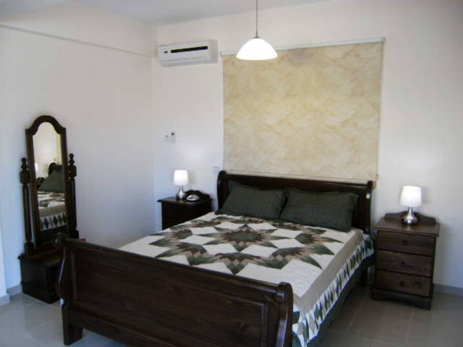 Master bedrom with bedside lamps and dressing mirror.