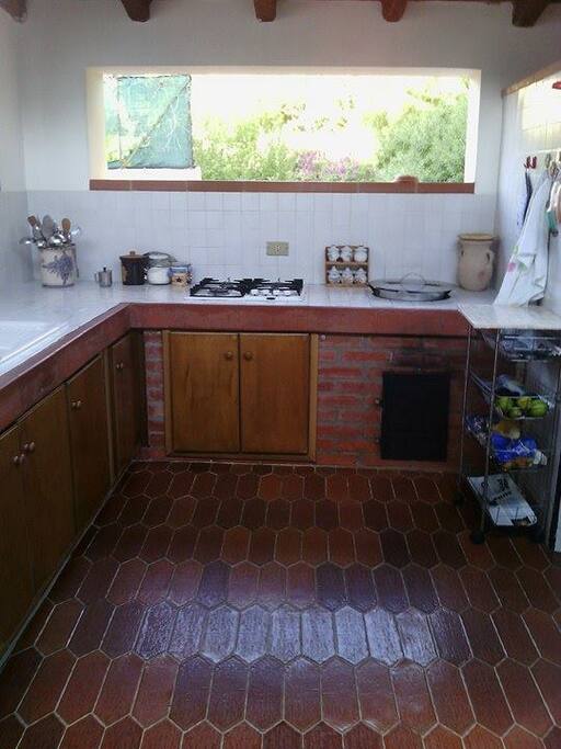 Cucina all'esterno munita di fornelli a gas e forno a legna
