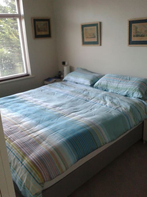 Double bed, built-in wardrobe, two bedside tables, full length mirror, reading lamps. The room is carpeted. This bedroom is located at the back of the house overlooking the garden.