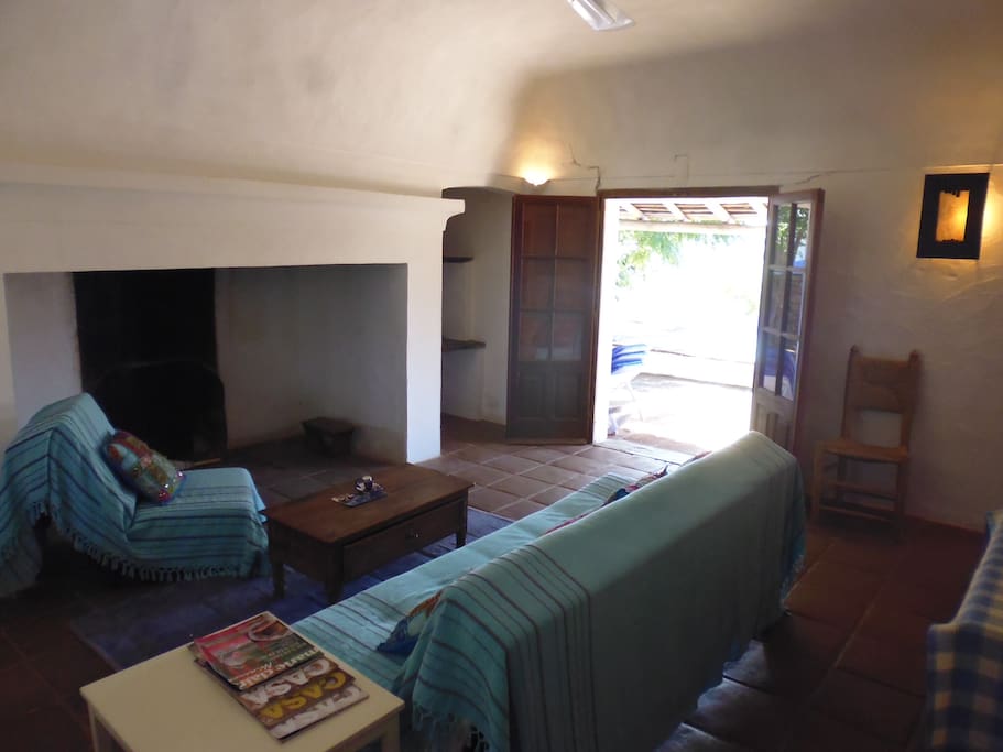 CASA PISCINA Livingroom with big fireplace and doors to the pool area